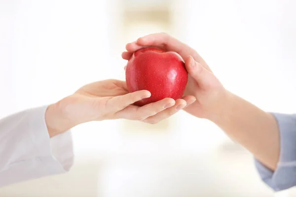 Hand of nutritionist giving apple to patient — Stock Photo, Image