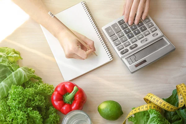 Jeune femme calculant les calories à table. Concept de perte de poids — Photo