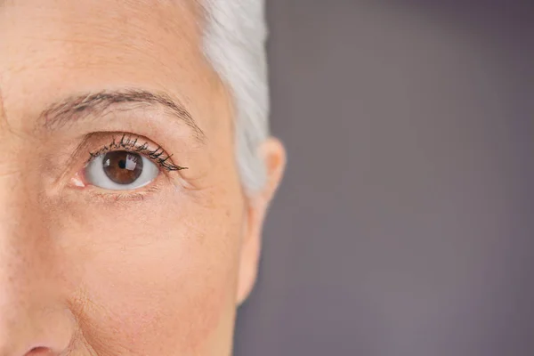 Vista de close-up da bela mulher idosa no fundo cinza — Fotografia de Stock