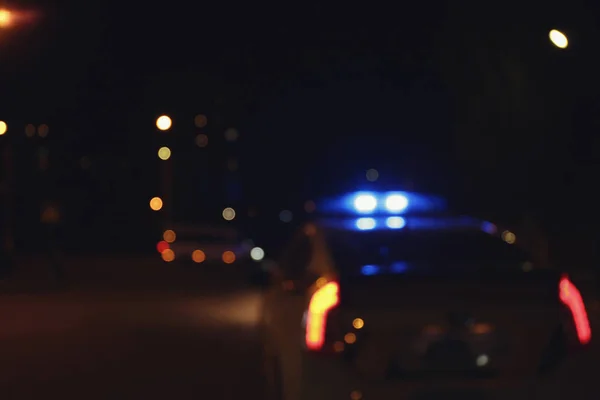 Carro da polícia borrado à noite — Fotografia de Stock