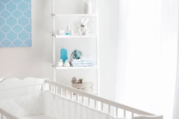 Красивая светлая комната с кроваткой и игрушками на полках — стоковое фото