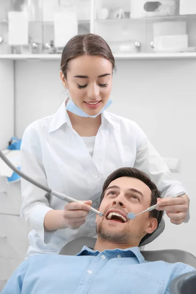 Дантист сверлит зубы пациенту в клинике — стоковое фото