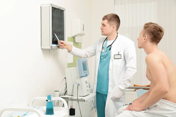 Orthopäde zeigt Patient in Klinik Röntgenbild — Stockfoto