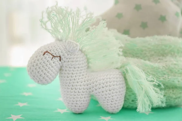 Cute baby toy on bed in room — Stock Photo, Image