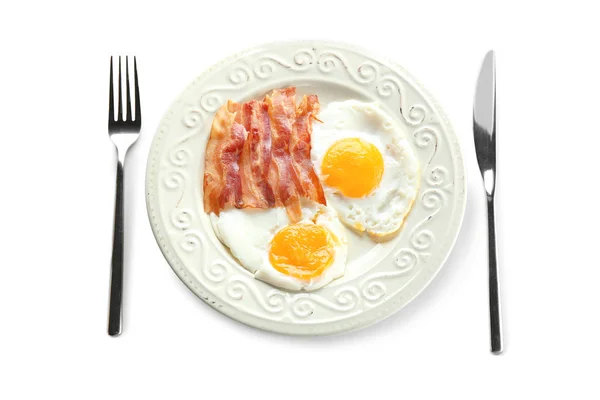 Plate with fried eggs, bacon and cutlery — Stock Photo, Image