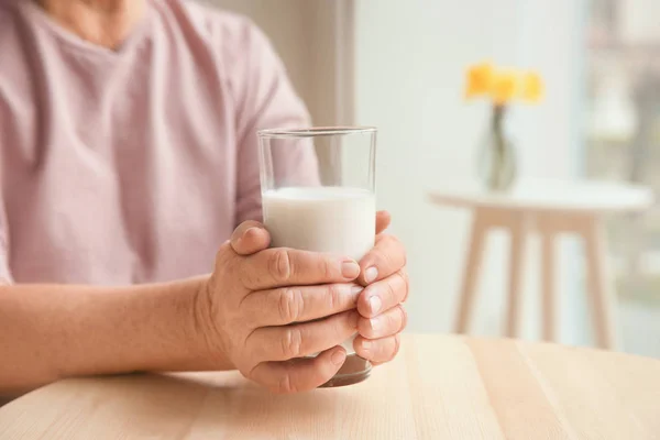 Vieille femme tenant verre avec du lait — Photo