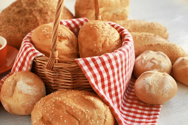 Panier en osier et délicieux pain sur table en bois — Photo