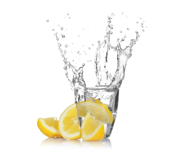 Slice of lemon falling into glass with water — Stock Photo, Image