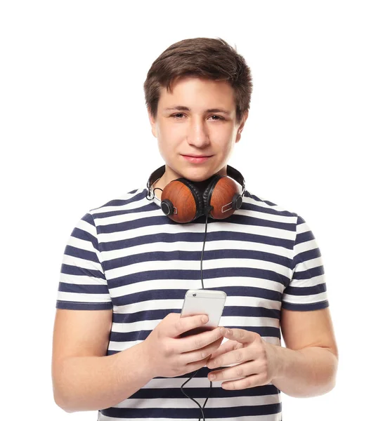 Cute teenage boy with mobile phone and headphones on white background Stock Image