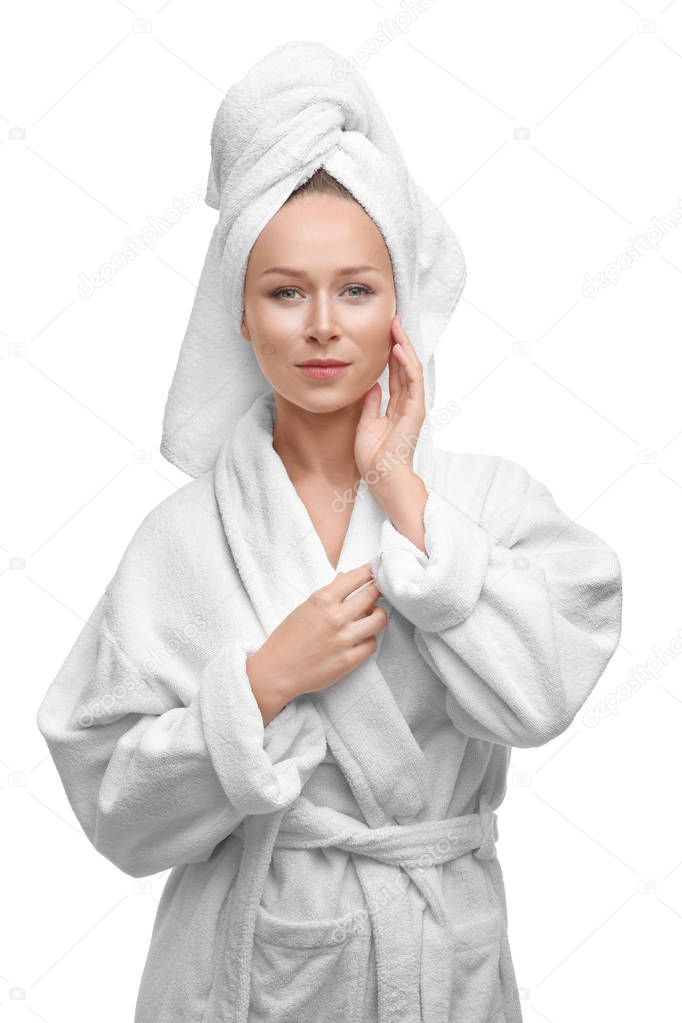 Beautiful young woman in bathrobe after shower on white background