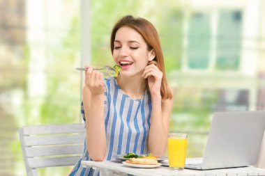 Genç bayan kahvaltısını evde yapıyor.