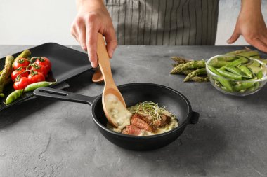 Adam kızartma tavası dilimlenmiş biftek sosu ekleme