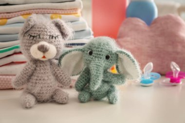 Şirin örgü oyuncak ve bebek giysileri masada