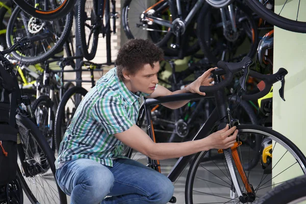 Genç adam Bisiklet dükkânında seçme