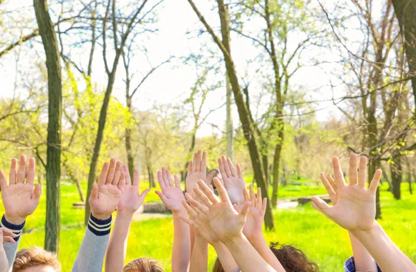 Νέοι βάζοντας τα χέρια στον αέρα μαζί σε εξωτερικούς χώρους. Έννοια του εθελοντισμού — Φωτογραφία Αρχείου