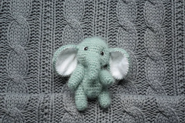 Örme arka plan üzerinde sevimli el yapımı oyuncak fil