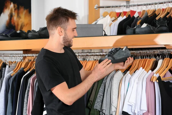 Giovane uomo che sceglie scarpe nel centro commerciale — Foto Stock