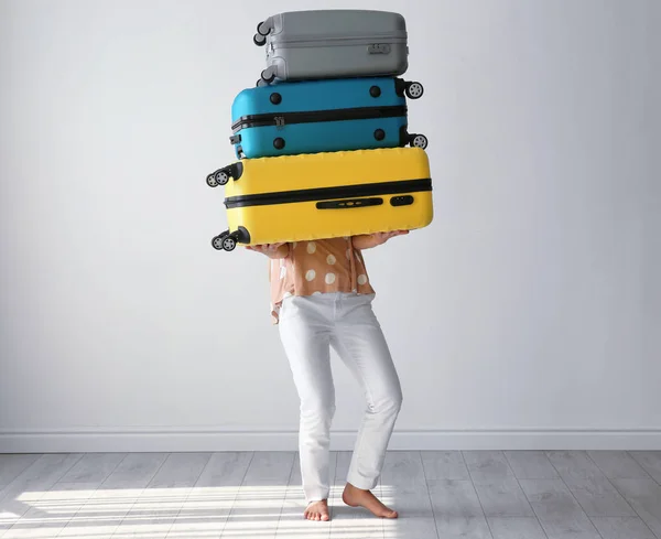 Mujer joven con maletas en la habitación. Concepto de sobrepeso de equipaje — Foto de Stock