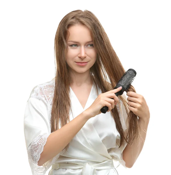 Mulher bonita penteando seu cabelo após o chuveiro no fundo branco — Fotografia de Stock