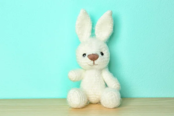 Cute knitted toy bunny on color background — Stock Photo, Image