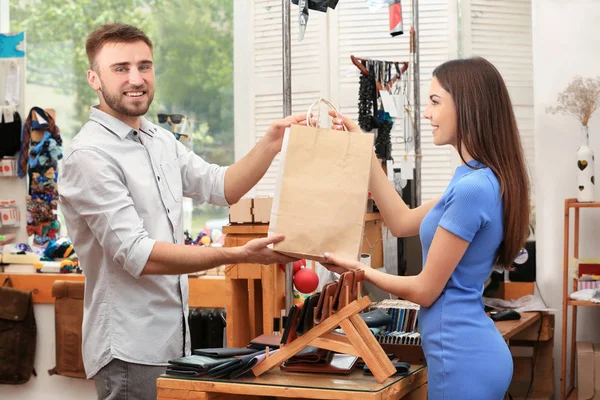 Vendedor e comprador com sacos de compras perto do balcão — Fotografia de Stock