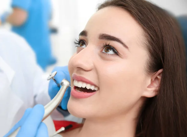 Dentist drilling patient's teeth in clinic — Stock Photo, Image
