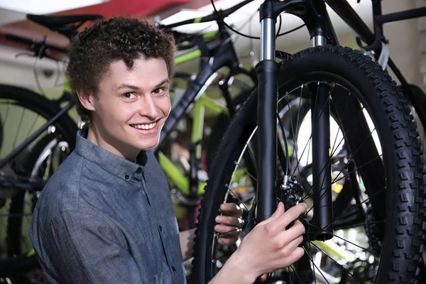 Jongeman kiezen fiets in de winkel — Stockfoto