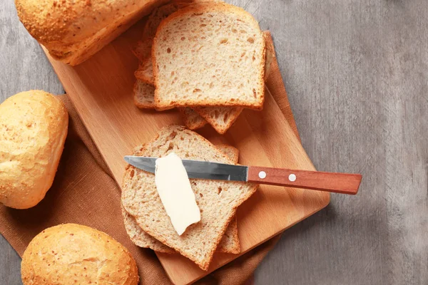 Roti lezat dan sepotong mentega di meja kayu — Stok Foto