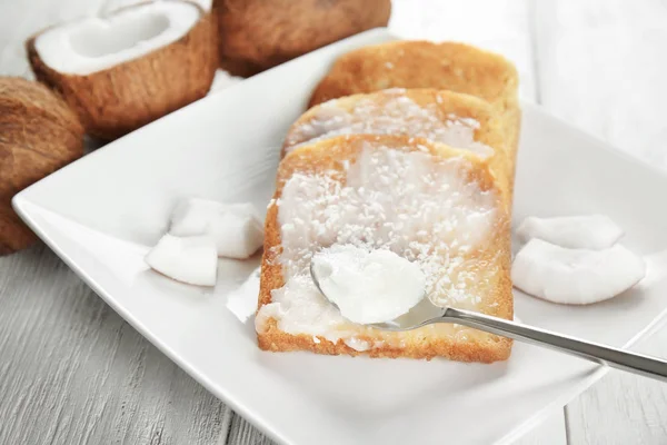 Deliziosi toast con olio di cocco in piatto sul tavolo — Foto Stock