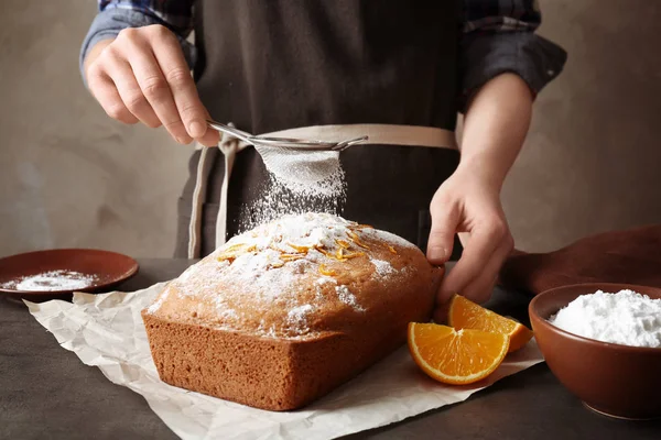 Woman covering citrus cake — Stock Photo, Image