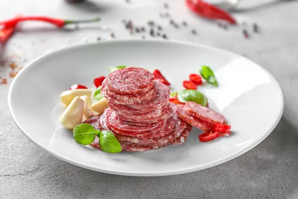 Deliziosa salsiccia affettata con aglio e peperoncino sul piatto — Foto Stock