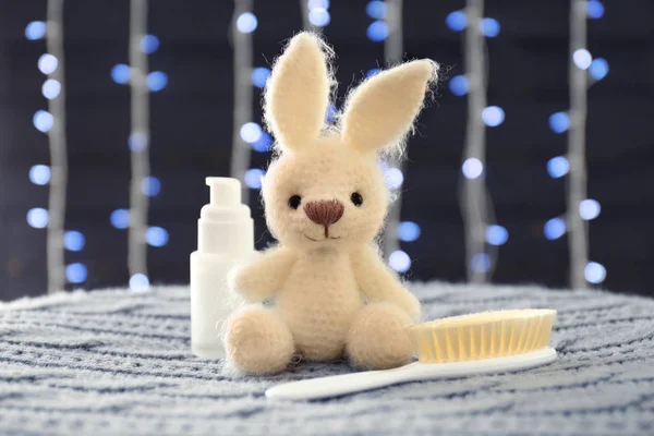 Knitted toy bunny and shower accessories on blurred background — Stock Photo, Image