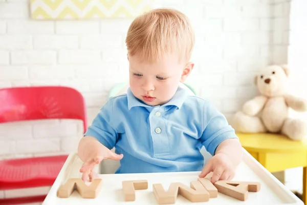 Milý Chlapeček Hraje Dřevěnými Dopisy Zatímco Sedí Křesle Vysoké — Stock fotografie