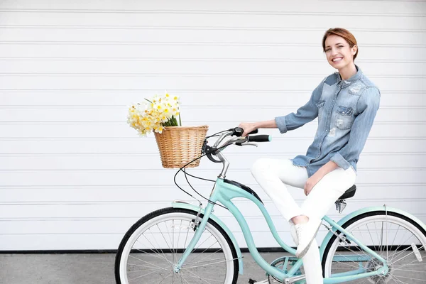 Chica joven con bicicleta y cesta de flores — Foto de Stock