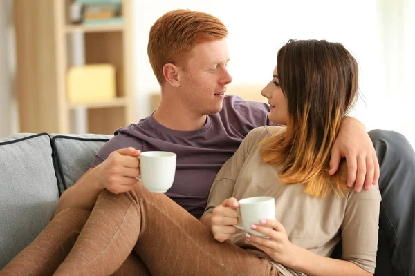 Schönes junges Paar ruht sich zu Hause auf Sofa aus — Stockfoto