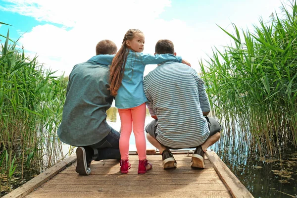 Gay couple with daughter on a pier — Stock Photo, Image