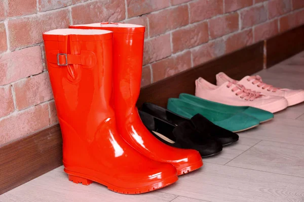 Red wellington boots and different shoes