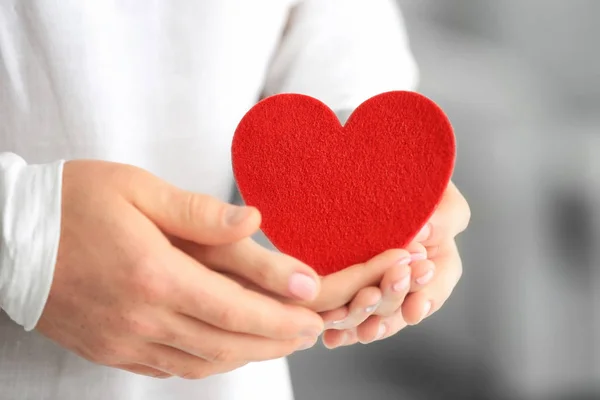 Lovely couple holding small red heart, closeup — Stock Photo, Image