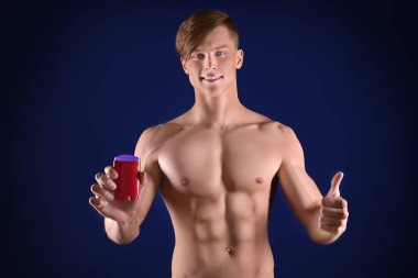 Deodorant koyu mavi arka plan ile yakışıklı genç