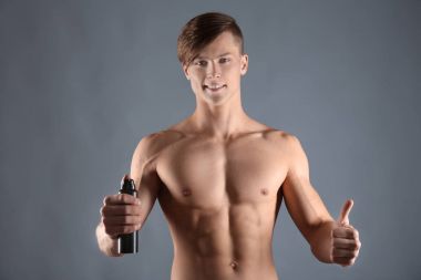 Yakışıklı delikanlı ile deodorant gri arka plan üzerinde
