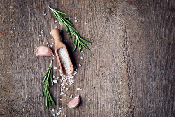 Holzlöffel mit Salz und frischem Rosmarin auf dem Tisch — Stockfoto