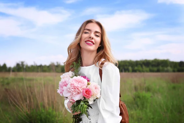 シャクヤクの花束を持つ若い女性 — ストック写真