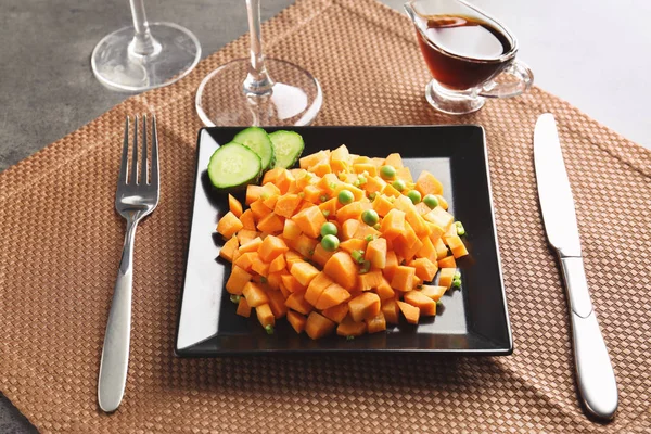 Placa cuadrada negra con deliciosa ensalada de zanahoria en la mesa — Foto de Stock