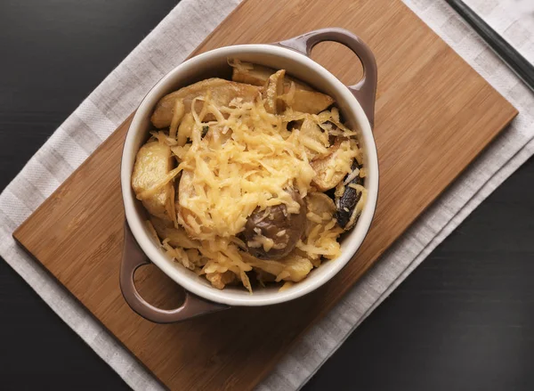 Caçarola com deliciosa batata assada e queijo na mesa escura — Fotografia de Stock