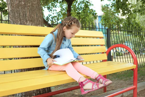 Söt tjej med notebook på bänk — Stockfoto