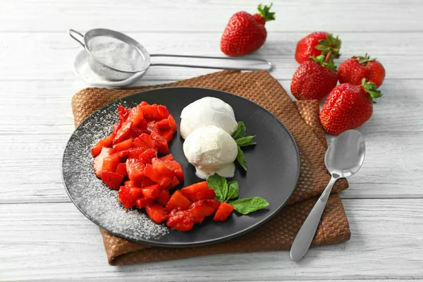 Plate with delicious sliced strawberry, mint leaves and ice-cream on wooden table — Stock Photo, Image