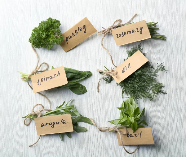 Fresh herbs and papers with written names — Stock Photo, Image