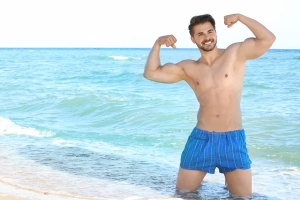 Bello giovane uomo sulla spiaggia — Foto Stock