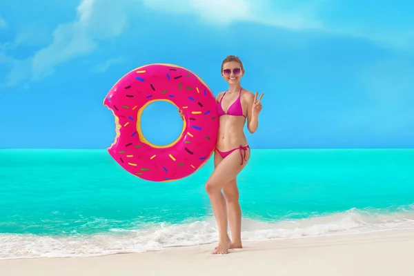 Mujer con donut inflable colorido — Foto de Stock