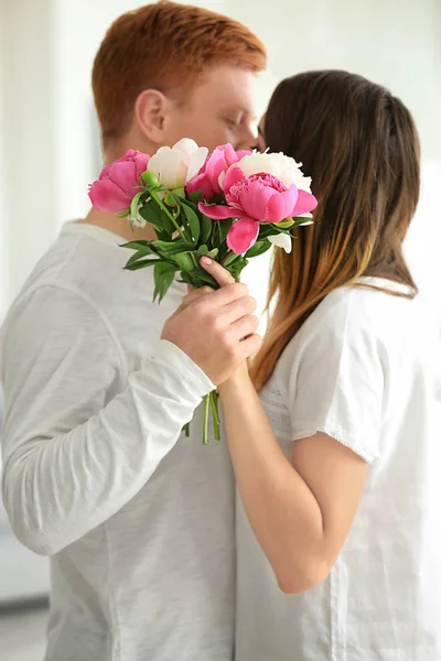 Linda pareja joven con ramo de flores en casa —  Fotos de Stock